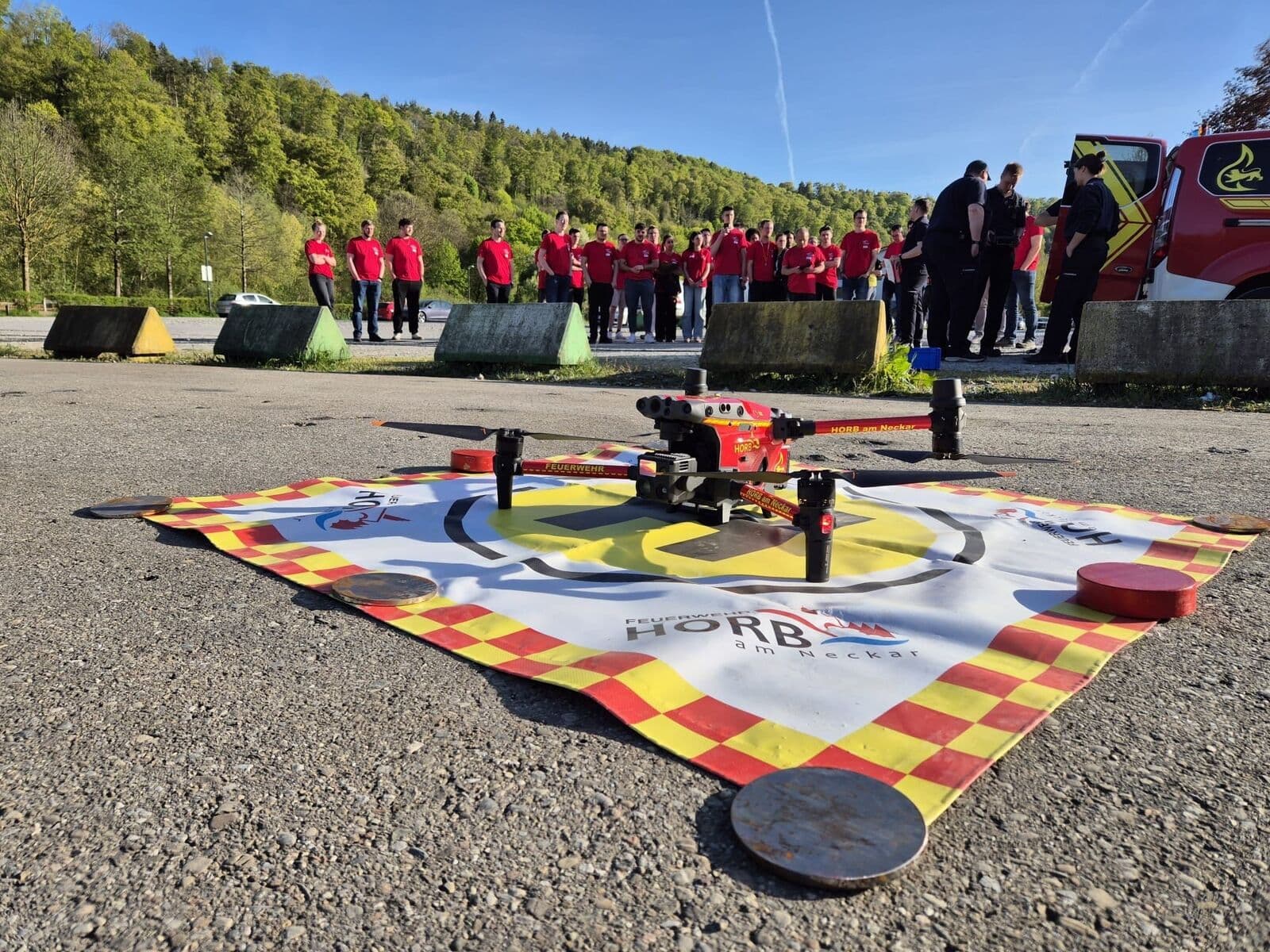 Einsatzdrohne der Feuerwehr Horb am Neckar auf dem Landeplatz, Teilnehmende schauen zu