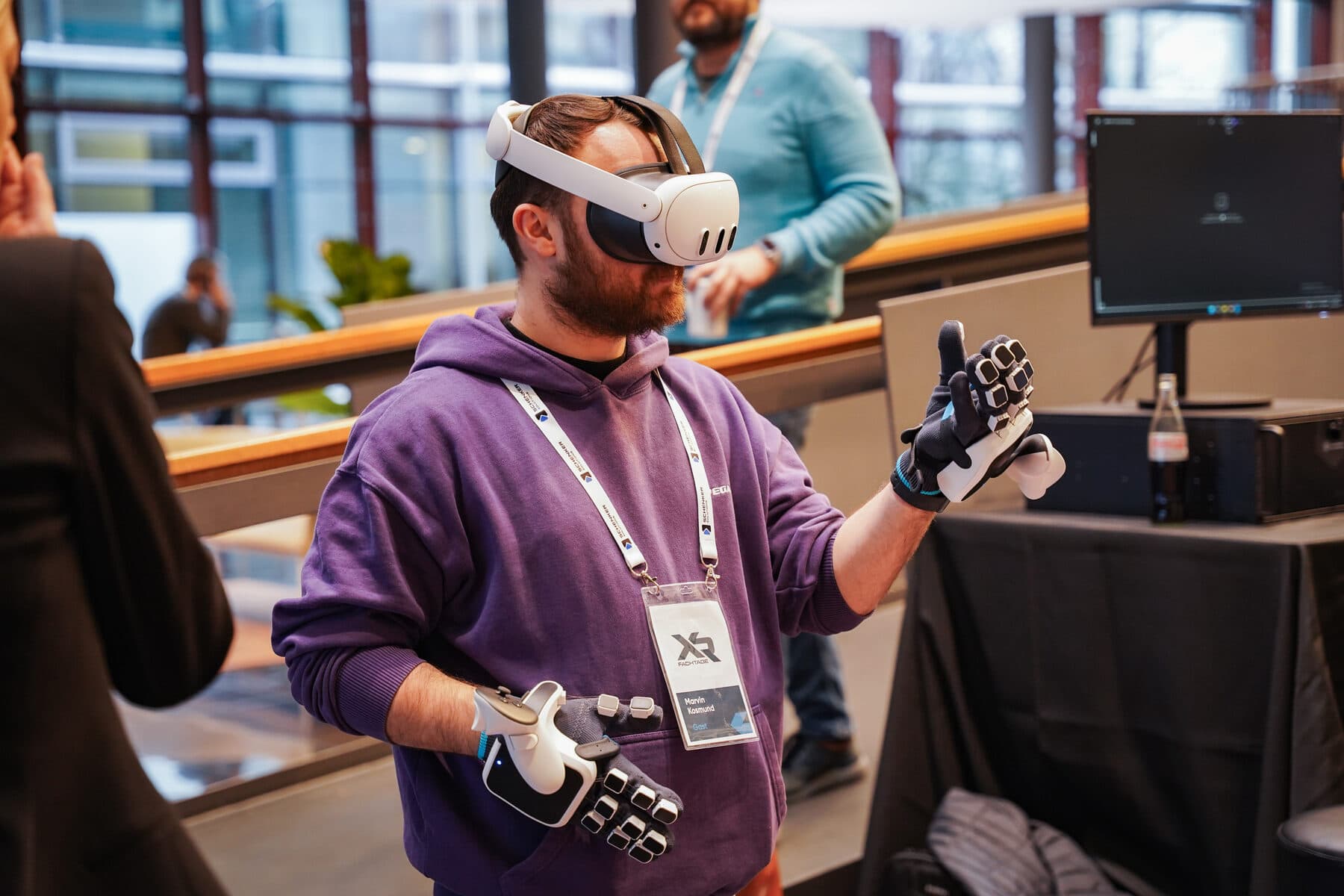 Besucher testet ein VR-Headset mit Haptik-Handschuhen